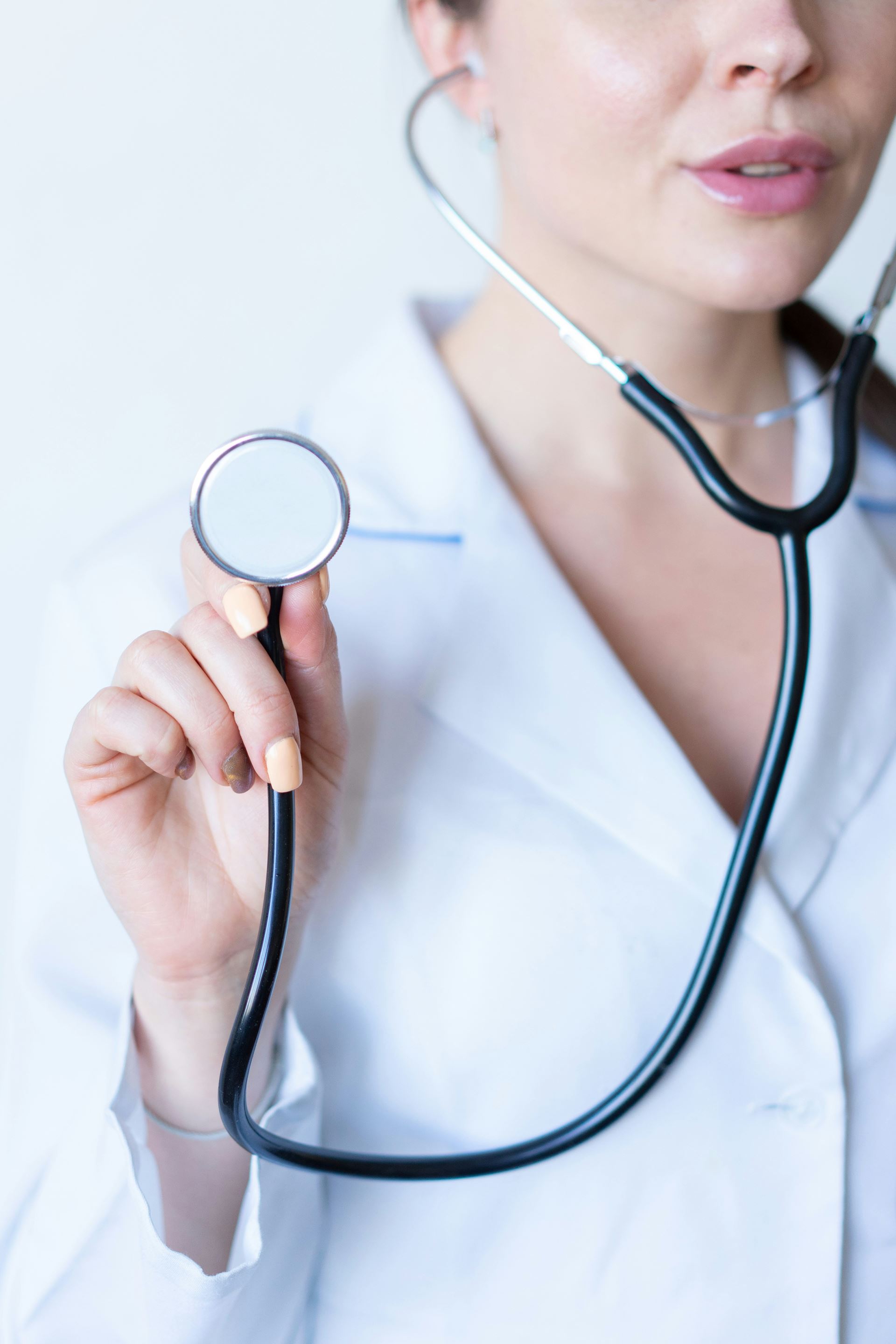 picture of a doctor in a white coat holding a stethoscope up